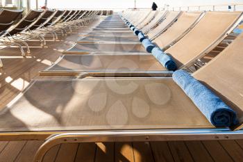 empty chairs in outdoor lounge area on stern of cruise liner