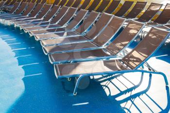 empty chairs in sunbathing area on stern of cruise liner