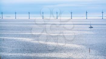 Travel to Denmark - calm Baltic Sea with offshore wind farm Middelgrunden in Oresund near Copenhagen city in blue autumn morning