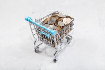 shopping cart with russian coins on concrete board