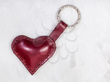 red leather heart shape keychain on concrete board