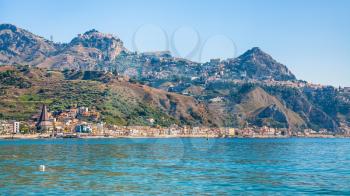 travel to Italy - Taormina city on mountain and Giardini Naxos town on waterfront of Ionian sea in Sicily in summer day