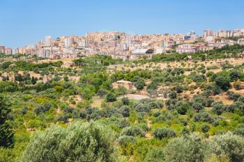 travel to Italy - fruit gardens and view of Agrigento town from Valley of the Temples in Sicily