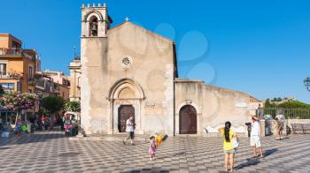 TAORMINA, ITALY - JULY 2, 2011: people near ex Chiesa Sant Agostino in Piazza IX Aprile in Taormina city in Sicily. Since 1985 this medieval church is used as a library and multipurpose building