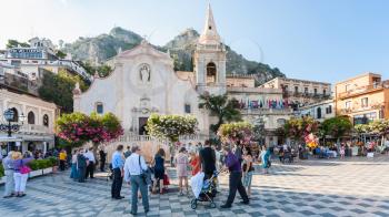 TAORMINA, ITALY - JULY 2, 2011: people on Piazza IX Aprile near Church of San Giuseppe in Taormina city in Sicily. The church was built between late 1600 and early 1700
