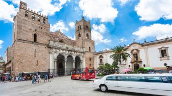 MONREALE, ITALY - JUNE 25, 2011: people and bus on square of Duomo di Monreale town in Sicily. The cathedral of Monreale is one of the greatest examples of Norman architecture, it was begun in 1174