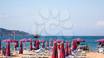 GIARDINI NAXOS, ITALY - JULY 6, 2011: view of urban beach in Giardini Naxos village afternoon. Naxos was founded by Thucles the Chalcidian in 734 BC, and since 1970s it has become a seaside-resort