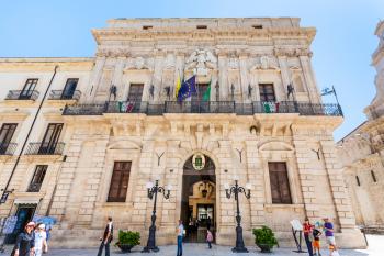SYRACUSE, ITALY - JULY 3, 2011: people near Municipality (Town Hall) of Syracuse on piazza Duomo in Sicily. The city is a historic town in Sicily, the capital of the province of Syracuse.