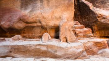 Travel to Middle East country Kingdom of Jordan - sculpture carved in sandstone wall of Siq passage to Petra town in winter