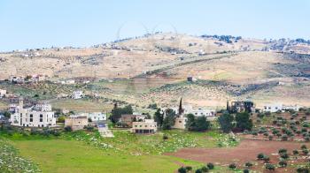 Travel to Middle East country Kingdom of Jordan - view of village and terraced gardens in Jordan in winter