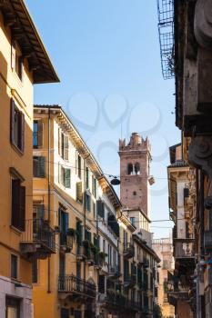 travel to Italy - view of tower Torre del Gardello through street Corso Porta Borsari in Verona city in spring