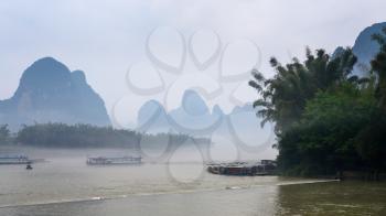 travel to China - passenger ships in mist over river near Xingping town in Yangshuo county in spring morning