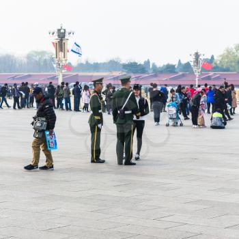 BEIJING, CHINA - MARCH 19, 2017: tourists and military men on Tiananmen Square in spring. Tiananmen Square is central city square in Beijing