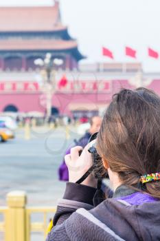 BEIJING, CHINA - MARCH 19, 2017: tourist photographs The Tiananmen monument (Gate of Heavenly Peace) on Tiananmen Square in spring. Tiananmen Square is central city square in Beijing