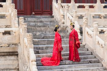 BEIJING, CHINA - MARCH 19, 2017: couple in chinese dresses on steps of Hall for Worship of Ancestors in Imperial Ancestral Temple (Taimiao) in Beijing Imperial city in spring.