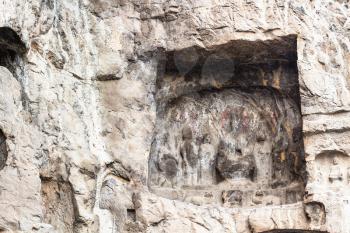 LUOYANG, CHINA - MARCH 20, 2017: reliefs in cave of Chinese Buddhist monument Longmen Grottoes (Longmen Caves). The complex was inscribed upon the UNESCO World Heritage List in 2000