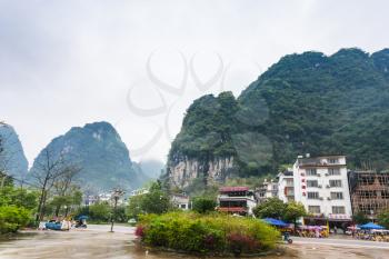 YANGSHUO, CHINA - MARCH 29, 2017: view of village square under karst mountains in Yangshuo county. Town is resort destination for domestic and foreign tourists because of scenic karst peaks