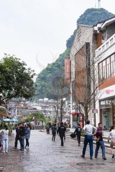 YANGSHUO, CHINA - MARCH 30, 2017: people on street in Yangshuo city in spring. Town is resort destination for domestic and foreign tourists because of scenic karst peaks