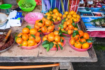 XINGPING, CHINA - MARCH 30, 2017: fresh mandarines on stall in market in Xing Ping town in Yangshuo county. The town was settled in 265 AD, Xingping is surrounded by great examples of Karst peaks