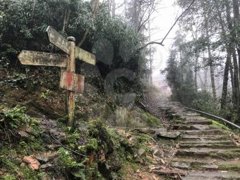 TIANTOUZHAI, CHINA - MARCH 24, 2017: direction sign to Tiantou village from mountain road in Dazhai country of Longsheng Rice Terraces (Longji Rice Terraces) in spring rainy day