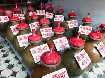 YANGSHUO, CHINA - MARCH 28, 2017: jugs with local alcohol drinks on city market in Yangshuo town. Baijiu is Chinese alcoholic beverage from strong distilled spirit, generally between 40 and 60%