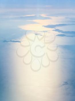 View from the airplane - above view of Aegean sea with islands in Greece in autumn sunrise