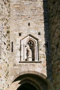 Travel to Occitanie, France - statue of Madonna in wall of Basilica of Saints Nazarius and Celsus (Eglise Saint-Nazaire de Carcassonne, Basilique Saint Nazaire) in Cite de Carcassonne