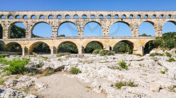 Travel to Provence, France - view of ancient Roman aqueduct Pont du Gard from dried riverbed of Gardon River near Vers-Pont-du-Gard town
