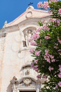 travel to Sicily, Italy - oleander tree and church Chiesa di San Giuseppe at Piazza 9 Aprile in Taormina city in summer day