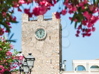 travel to Sicily, Italy - view of medieval clock tower (Torre dell Orologio) at Piazza IX Aprile in Taormina city in summer day