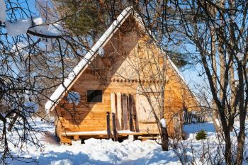 view of little timber chalet and wide skis in sunny winter day in Smolensk region of Russia