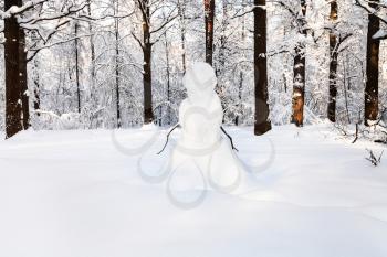 snowman on snowy meadow in Timiryazevskiy forest park of Moscow city in sunny winter morning