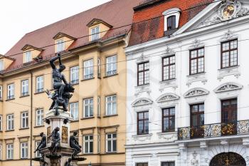 Travel to Germany - Hercules statue on Herkulesbrunnen fountain near rococo Schaezlerpalais palace on Maximilianstrasse street in Augsburg city in rainy spring day