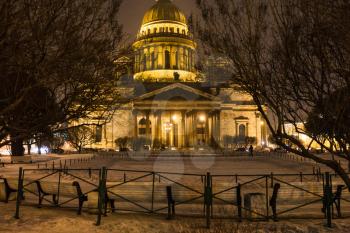 view of Saint Isaac's Cathedral from snow-covered garden St Isaac Square in Saint Petersburg city in night snowfall