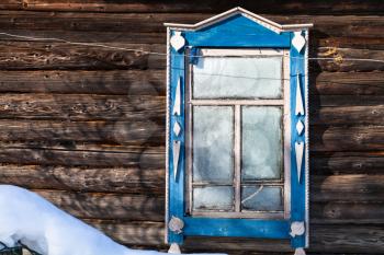 frozen window in wall of old wooden typical russian rural house in winter in little village in Smolensk region of Russia