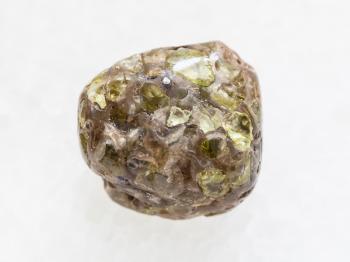 macro shooting of natural mineral rock specimen - polished Peridot gemstone on white marble background