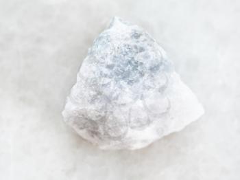 macro shooting of natural mineral rock specimen - rough gray Marble stone on white marble background
