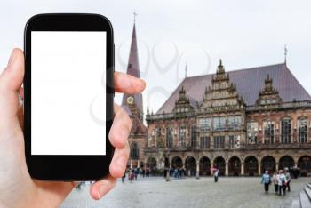 travel concept - tourist photographs Town Hall on Bremer Marktplatz (Bremen Market Square) in Germany in autumn on smartphone with cut out screen for advertising logo