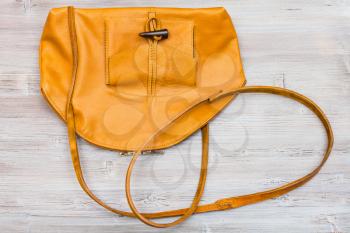 top view of handmade yellow leather bag on wooden table