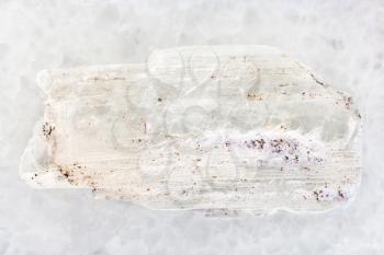 macro shooting of natural mineral rock specimen - raw crystal of Gypsum gemstone on white marble background