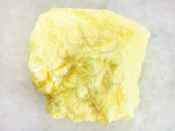 macro shooting of natural mineral rock specimen - rough native Sulphur stone on white marble background from Samara Region, Russia