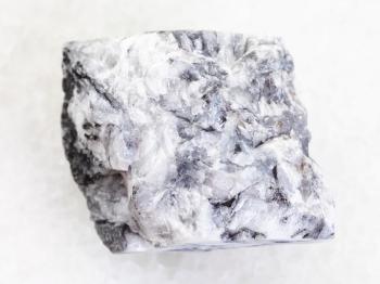 macro shooting of natural mineral rock specimen - raw magnesite stone on white marble background from Satka, South Ural Mountains, Russia