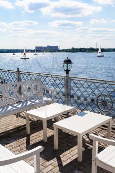 empty tables on waterfront of Klyazma river water reservoir of Moscow Canal in summer day