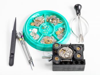 watchmaker workshop - set of tools and spare parts for repairing watch on white background