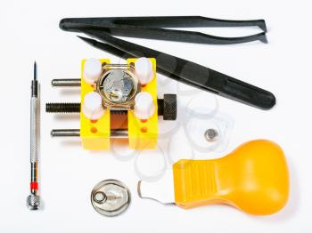 watchmaker workshop - top view of set of tools for replacing battery in watch on white background