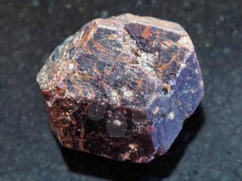 macro shooting of natural mineral rock specimen - raw crystal of dravite tourmaline gemstone on dark granite background from China
