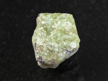 macro shooting of natural mineral rock specimen - raw crystal of Saamite (fluorapatite) gemstone on dark granite background from Lovozero Massif, Kola peninsula, Russia