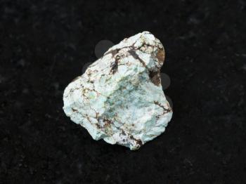macro shooting of natural mineral rock specimen - raw green Turquoise gemstone on dark granite background