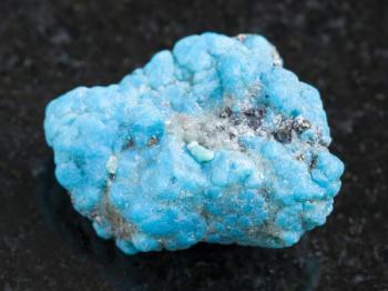macro shooting of natural mineral rock specimen - raw blue Turquoise gemstone on dark granite background from Mexico