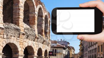 travel concept - tourist photographs Arena di Verona ancient Roman Amphitheatre in Verona city on smartphone with cut out screen for advertising logo